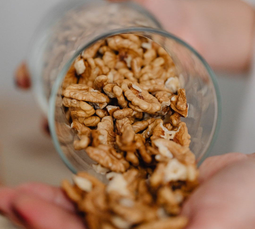 Composition esthétique de noix de Grenoble entières et décortiquées, symbolisant la beauté "In & Out