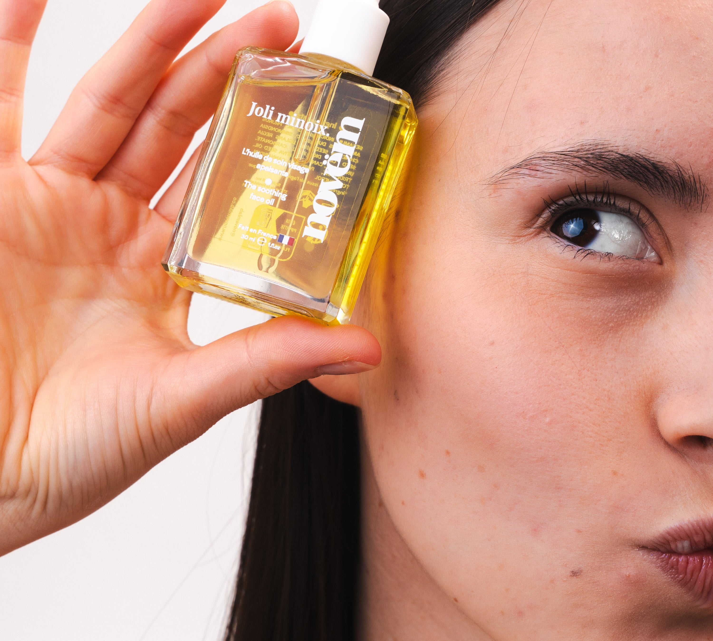 femme-appliquant-huile-visage-noix-anti-rougeurs-novem