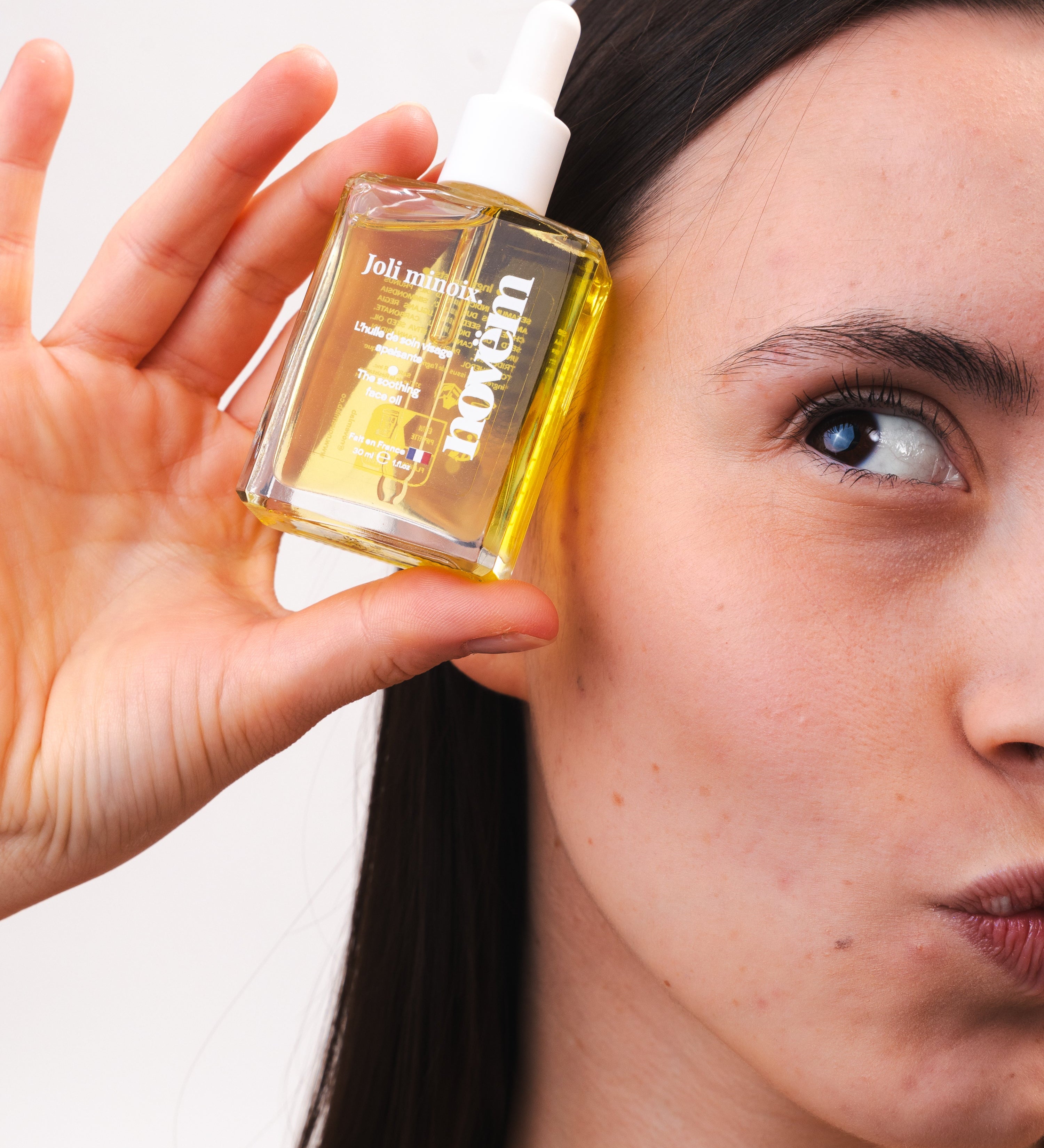 femme-appliquant-huile-visage-noix-anti-rougeurs-novem